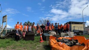 A group of adults stand outside of a recycling facility